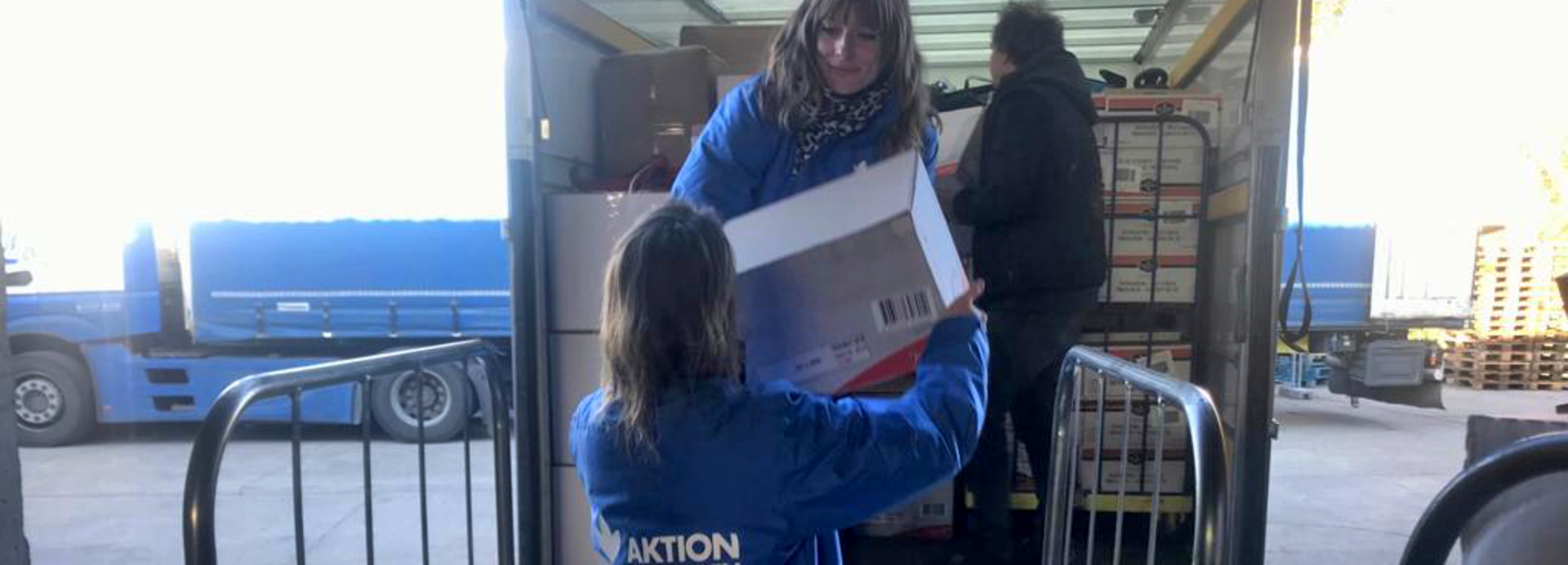 Mitarbeiterinnen von Aktion gegen den Hunger beladen Transporter