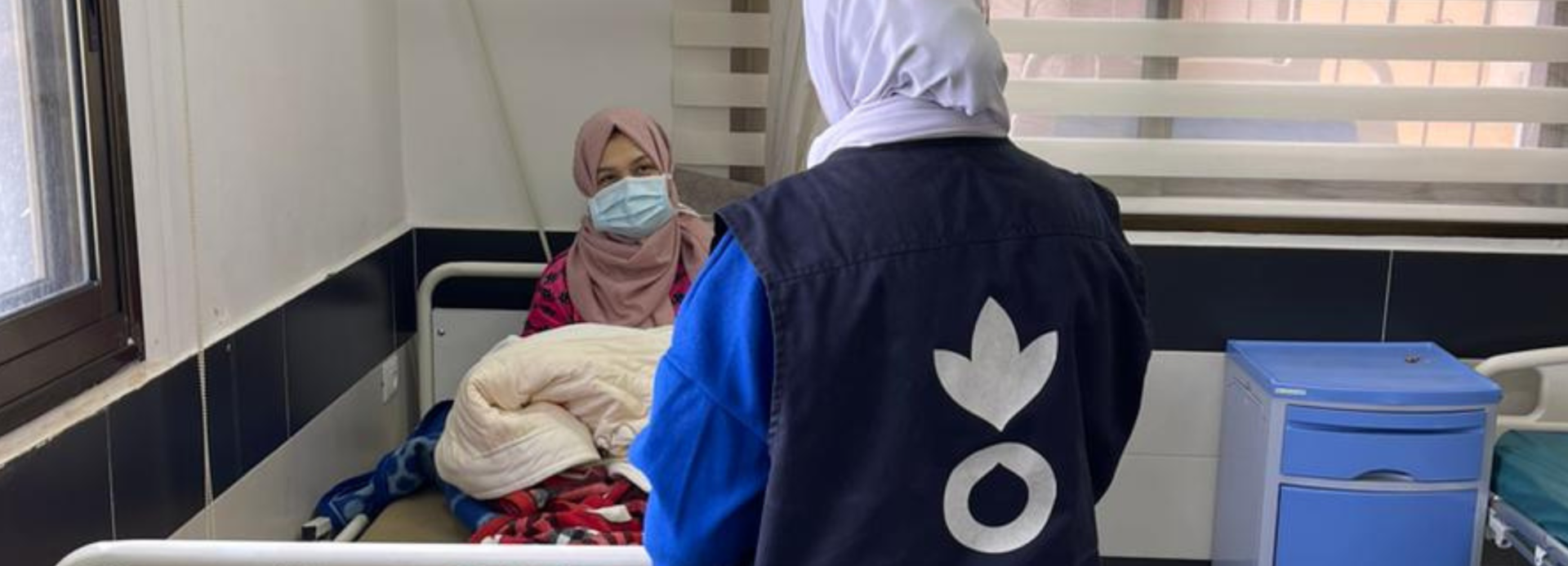 Eine Mitarbeiterin von Aktion gegen den Hunger spricht mit einer Frau in einem Krankenhaus in Gaza.