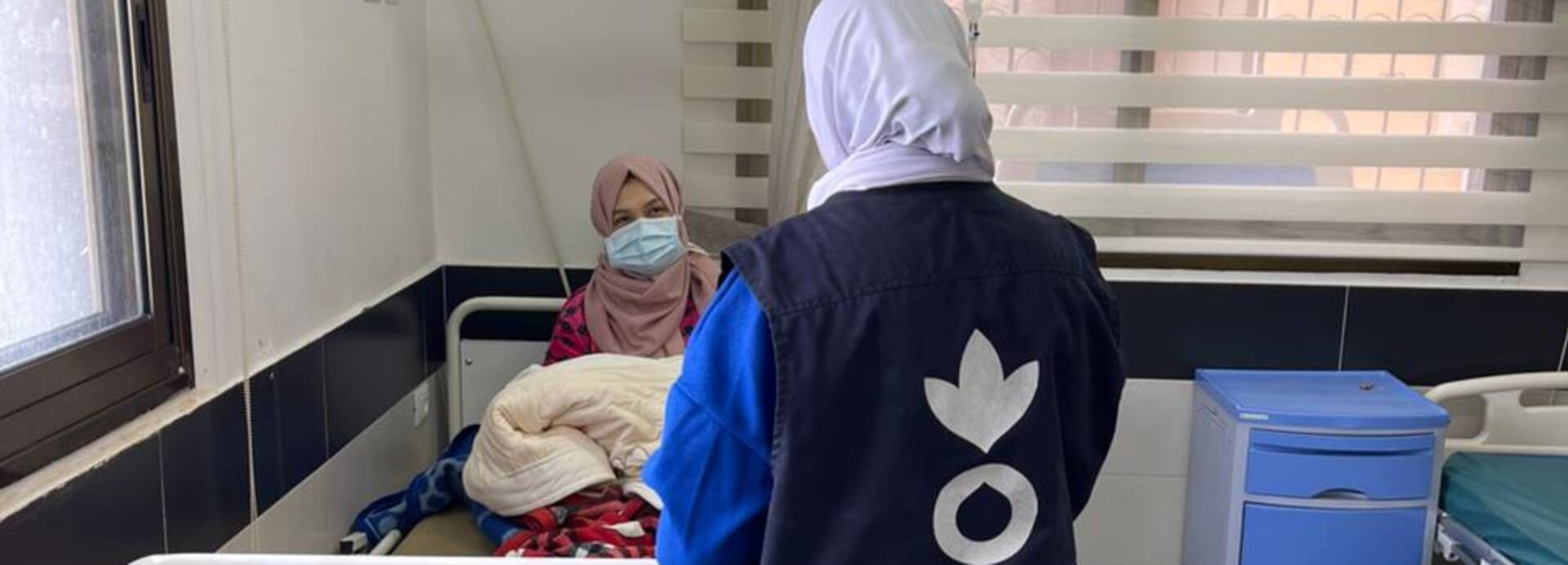 Eine Mitarbeiterin von Aktion gegen den Hunger spricht mit einer jungen Mutter im Al Awda Krankenhaus in Jabalia, Gaza