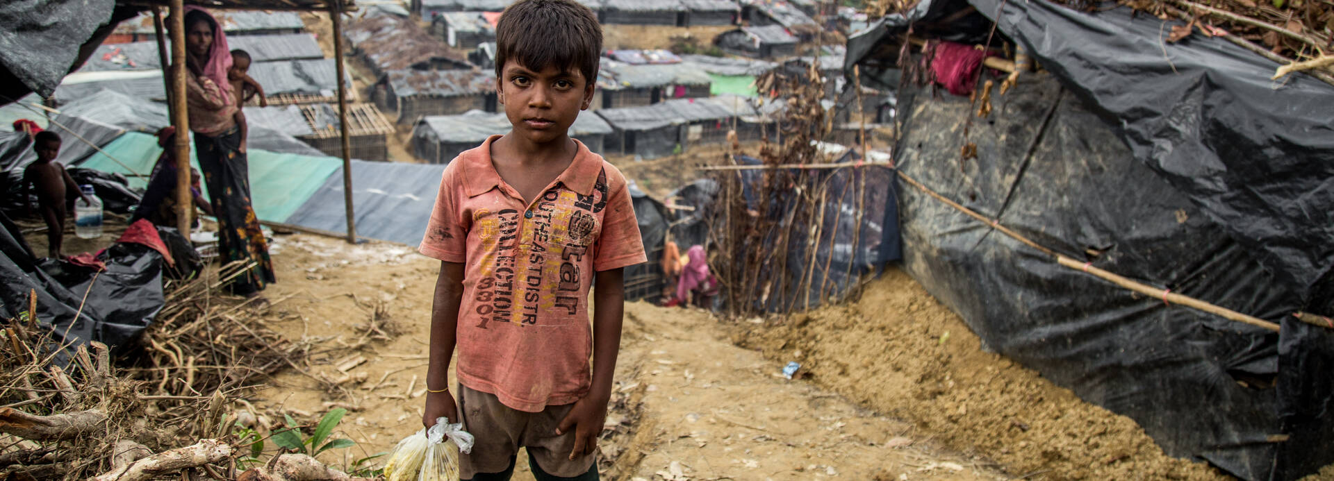 Muk Kashim, 8 Jahre, hält Säcke mit Nahrungsmittelhilfe in Cox's Bazar, Bangladesch