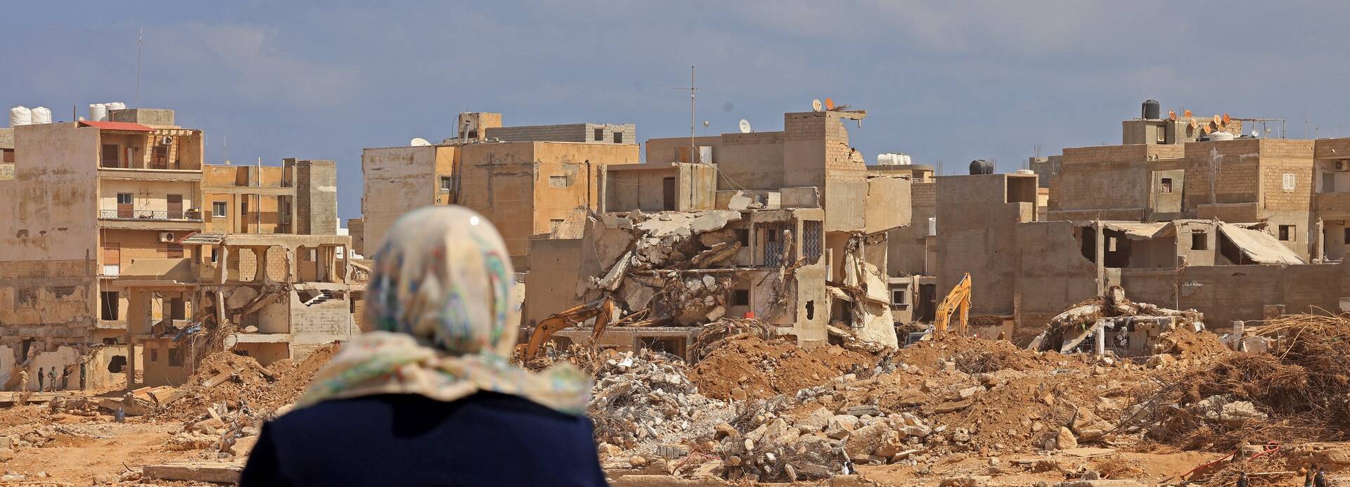 Eine Frau betrachtet die Trümmer zerstörter Gebäude in Libyens östlicher Stadt Derna.