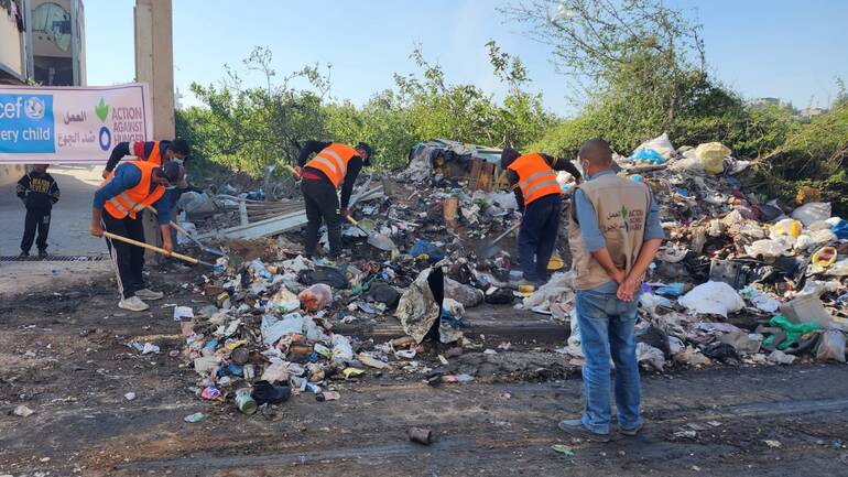 Helfende und Mitarbeitende von Aktion gegen den Hunger packen mit an beim Säubern der Umgebung von Müll. Helfende und Mitarbeitende von Aktion gegen den Hunger packen mit an beim Säubern der Umgebung von Müll.