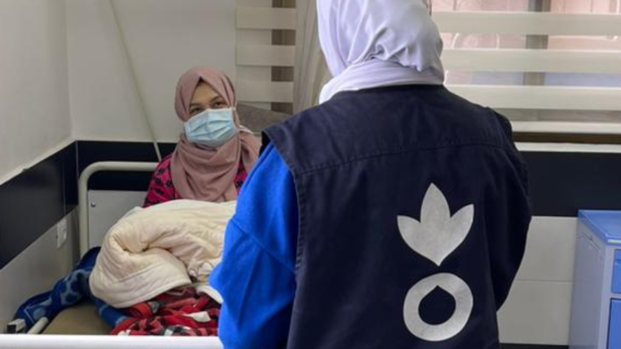 Eine Mitarbeiterin von Aktion gegen den Hunger spricht mit einer Frau in einem Krankenhaus in Gaza.