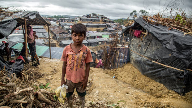 Muk Kashim, 8 Jahre, hält Säcke mit Nahrungsmittelhilfe in Cox's Bazar, Bangladesch