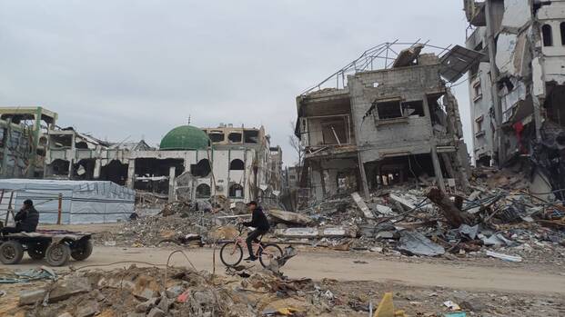 Eine Person fährt mit dem Fahrrad im Norden des Gazastreifens.