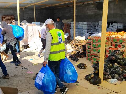 Ein Mitarbeiter von Aktion gegen den Hunger trägt Tüten aus einem Lebensmittellager zusammen mit anderen Helfenden in Rafah im Süden Gazas.